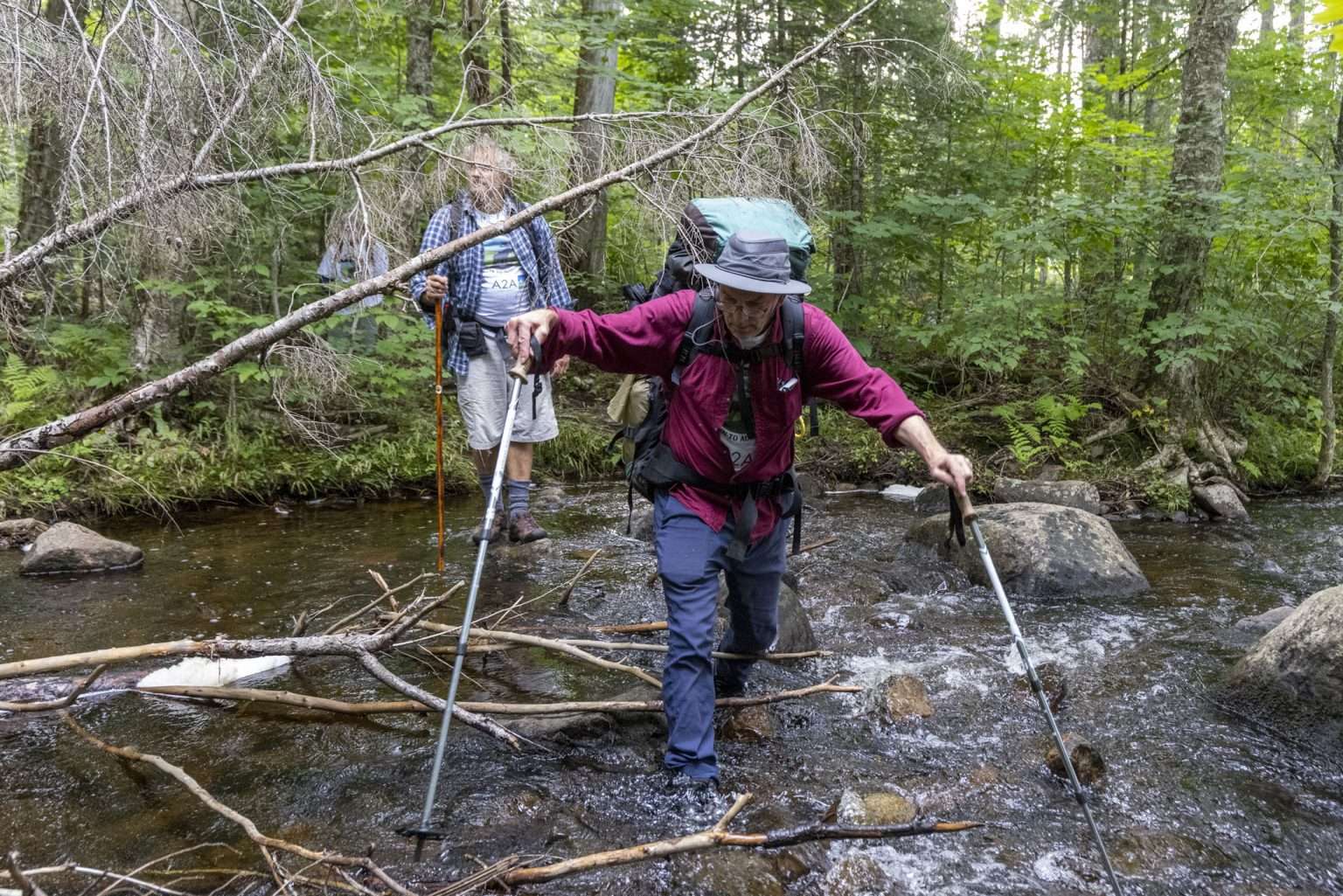 Advocates for the Adirondack To Algonquin collaborative make their way across a stream at the start of a 5 week hike