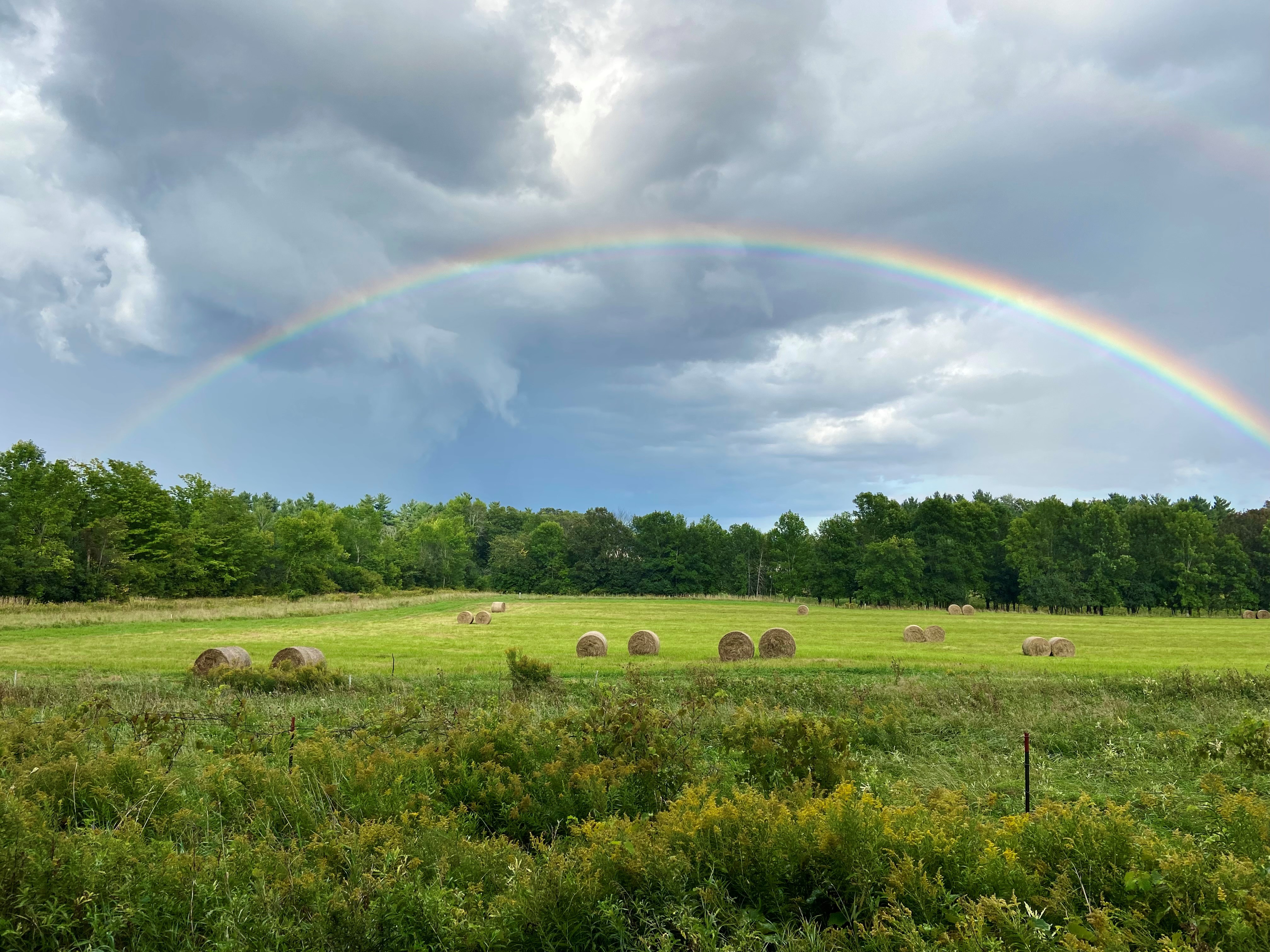a beautiful rainbow over a farm field