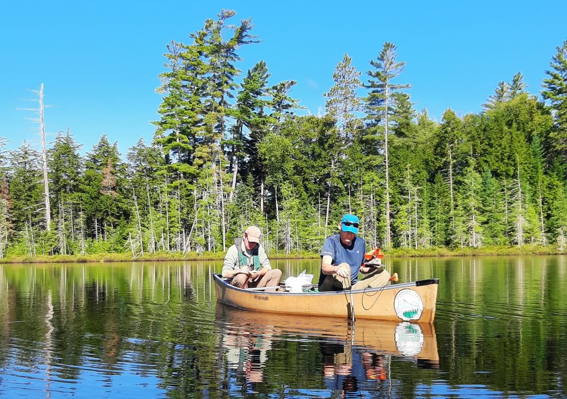 two people in a canoe taking water samples