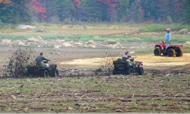 ATV riders in a large mud pit