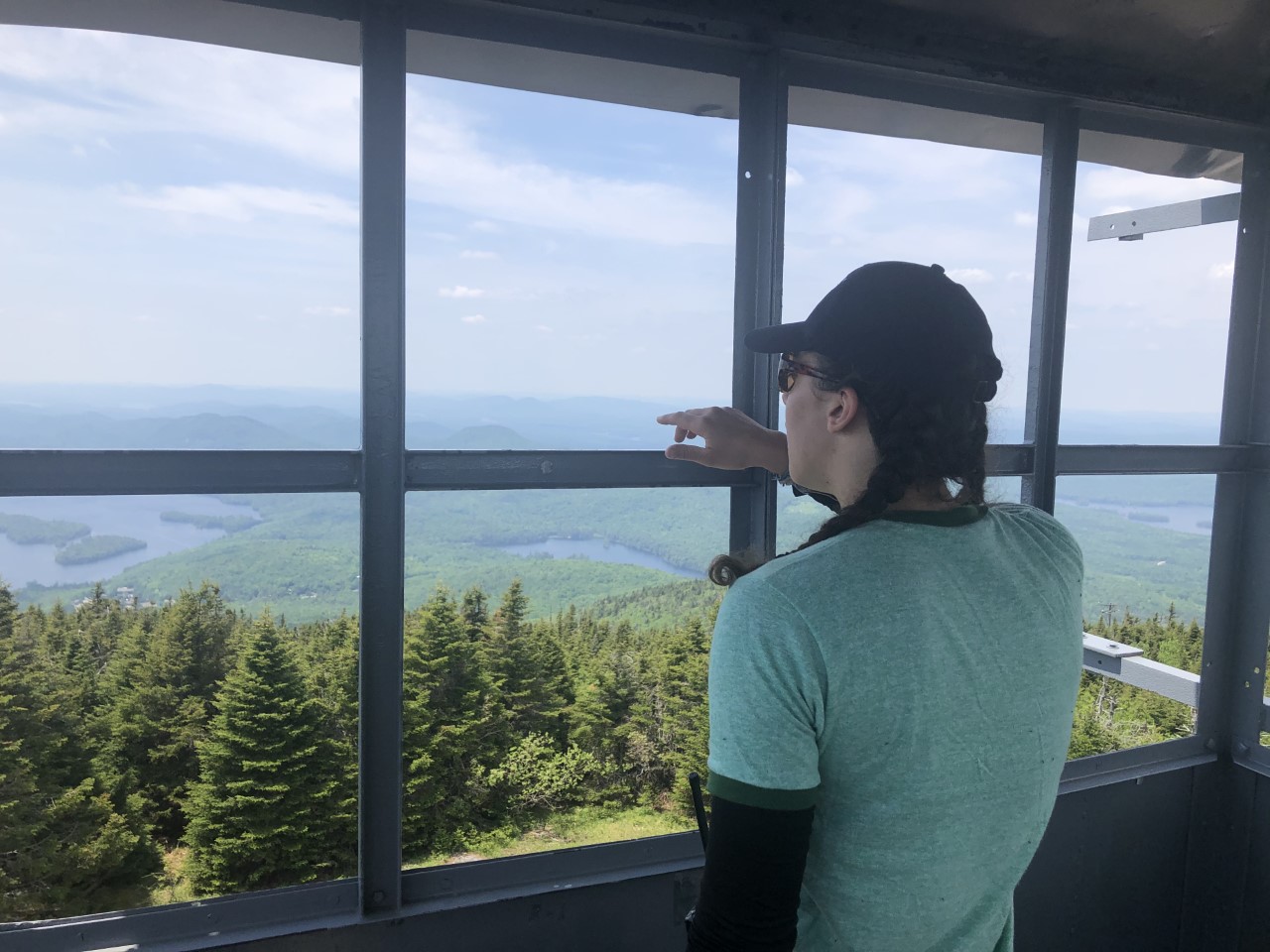 Andrea Shipton looking out of the Blue Mountain fire tower in the Adirondacks in summer 2021, when she was the summit steward