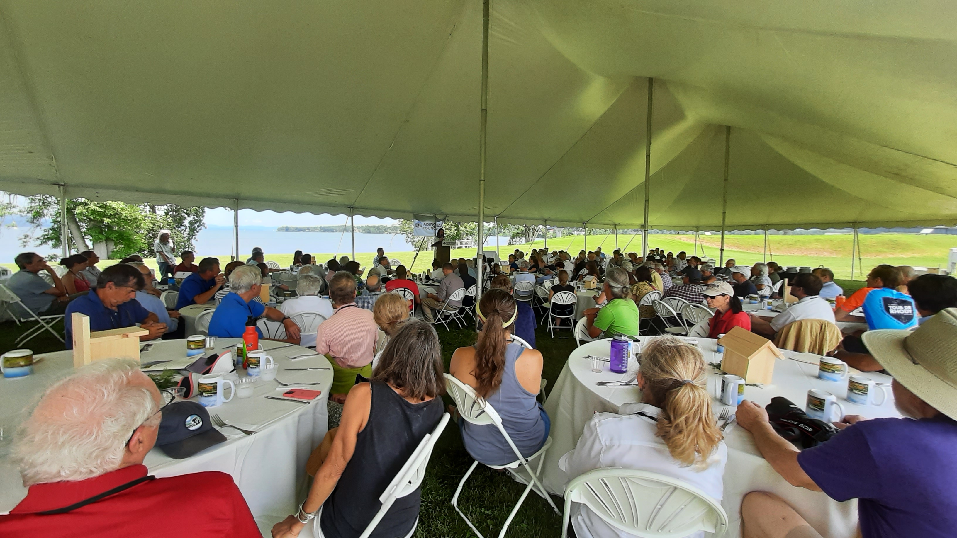 A crowd of over 200 enjoys the shade of the large tent during speeches, awards, and lunch
