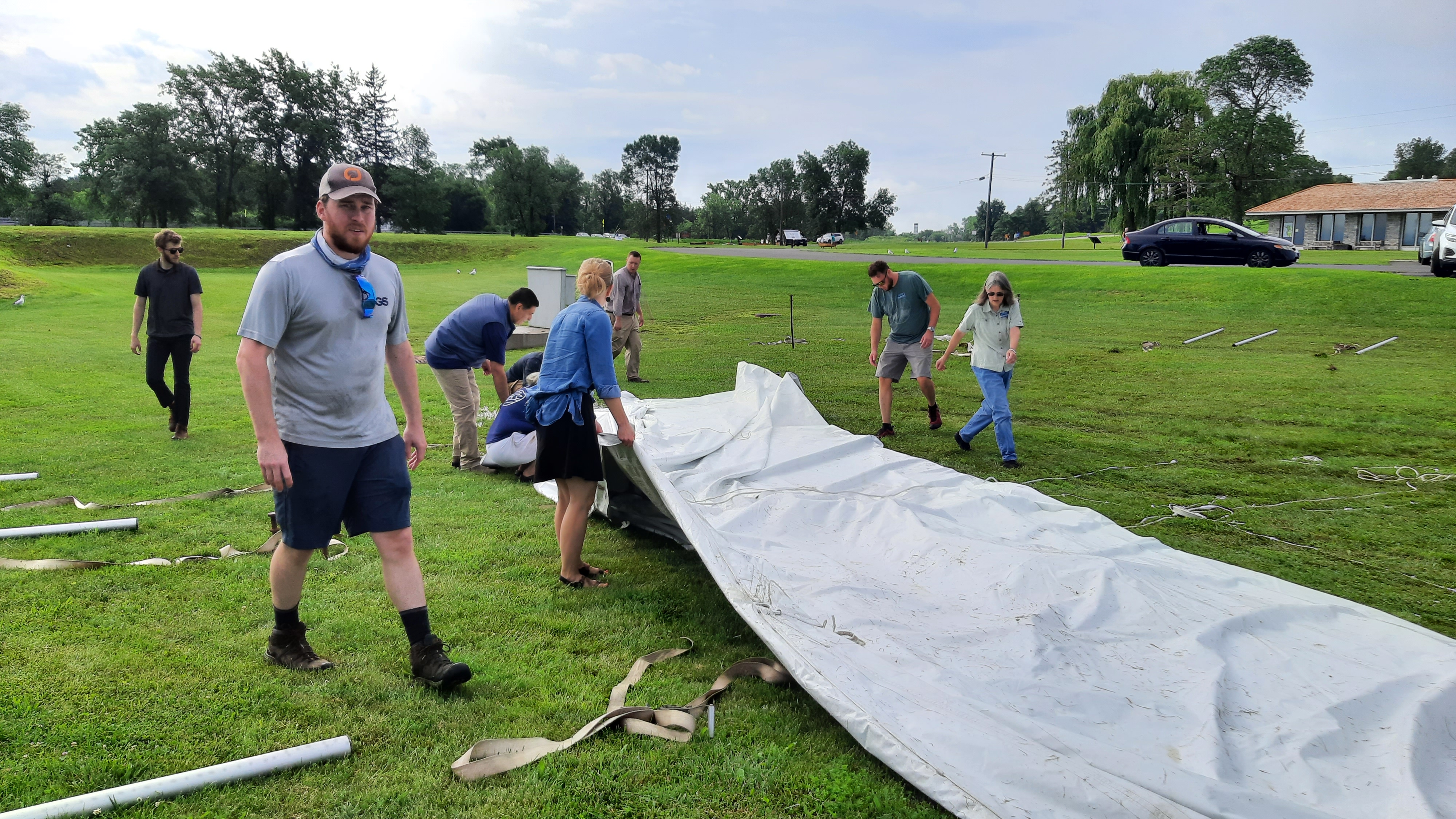 Adirondack Council staff, along with boyfriends, girlfriends, fiances, and spouses work on erecting the tent that fell over